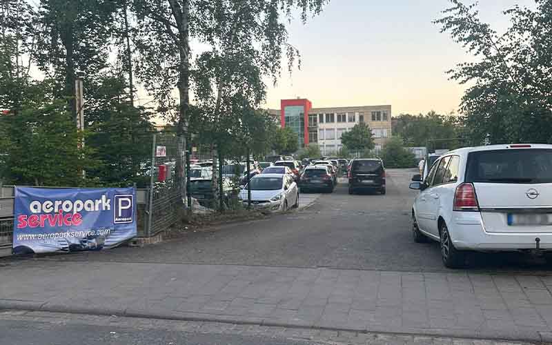 a parking lot with cars parked in front of a building