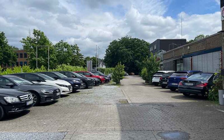a parking lot with cars parked in front of buildings